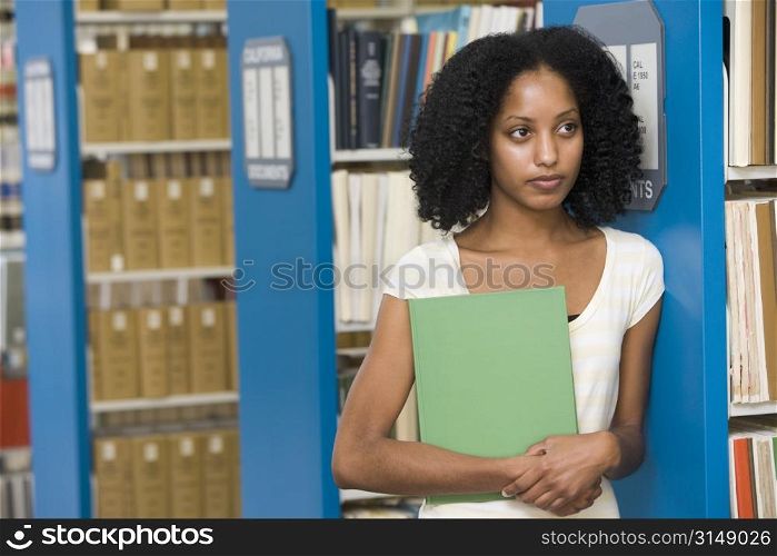 Woman in library holding book (depth of field)