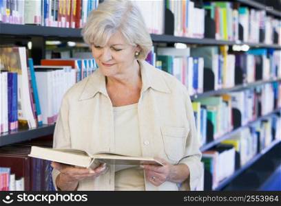 Woman in library reading book (depth of field)