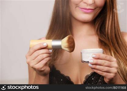 Woman in lingerie applying loose powder with brush. Woman in black lingerie applying anti-shine loose powder with brush to her body neckline. Pretty gorgeous girl beautifying. Fashion and makeup