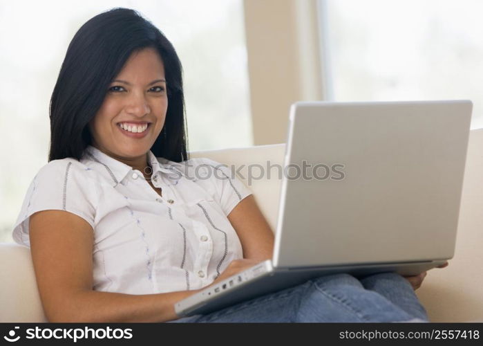 Woman in living room using laptop smiling