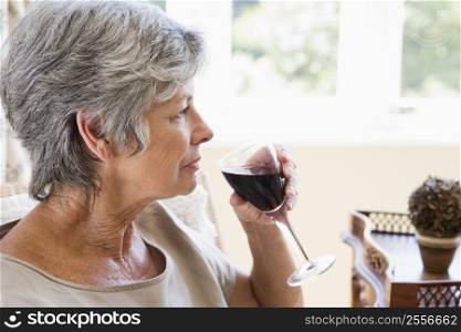 Woman in living room with glass of wine