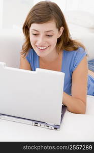 Woman in living room with laptop smiling