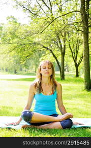 Woman in lotus yoga pose outside