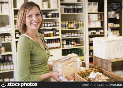 Woman in market looking at bread smiling