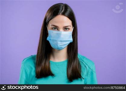 Woman in medical protective mask . Girl on violet studio background. Coronavirus concept. High quality photo. Woman in medical protective mask . Girl on violet studio background. Coronavirus concept.