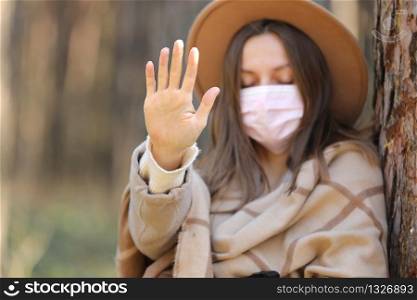 Woman in medical protective mask stop virus outdoors in the forest. Air pollution, environmental concept selective focus.. Woman in medical protective mask stop virus outdoors in the forest. Air pollution, environmental concept selective focus