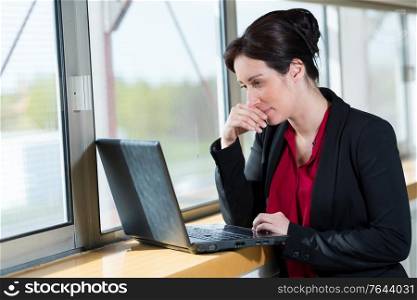 woman in office outfit looking at her laptop