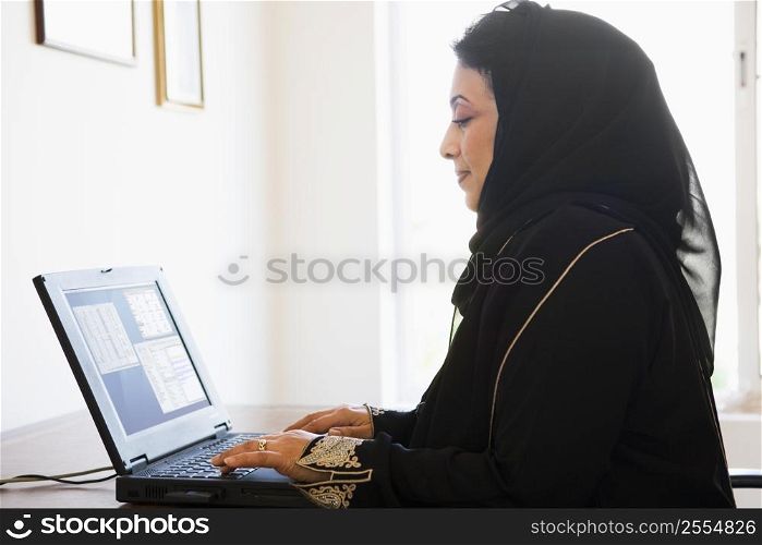 Woman in office with laptop (high key/selective focus)