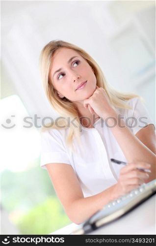 Woman in office writing on agenda