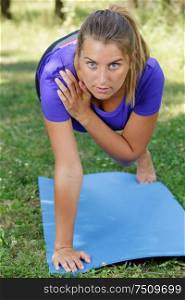 woman in one arm plank outdoors