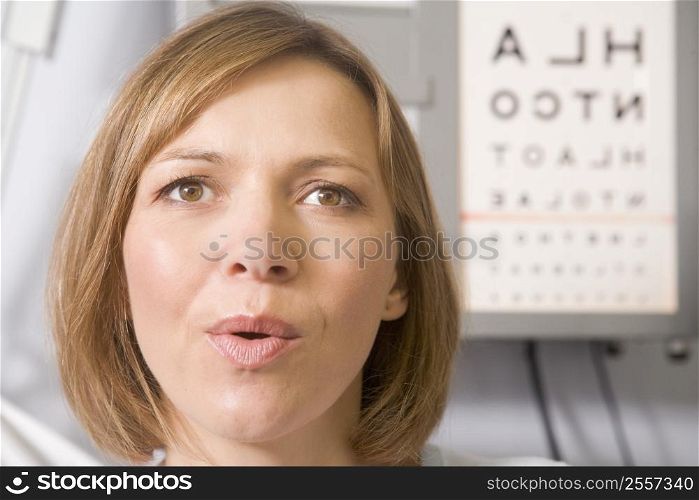 Woman in optometrist&acute;s exam room taking deep breath