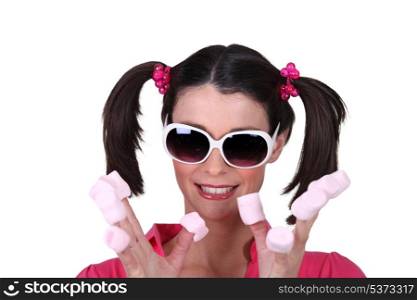 Woman in pigtails eating marshmallows