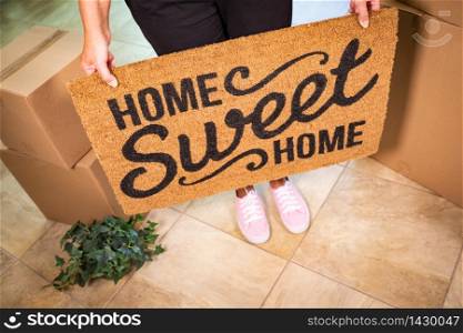 Woman in Pink Shoes Holding Home Sweet Home Welcome Mat, Boxes and Plant.