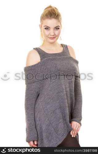 Woman in ponytail wearing gray long top sweater tunic with holes on shoulders. Stylish, autumnal outfit.. Woman wearing gray long top sweater tunic