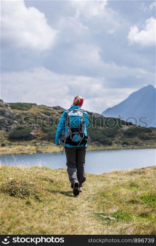 Woman in professional sportswear is hiking on the mountain, Austria
