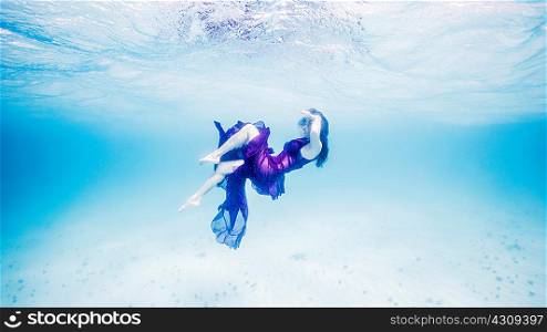 Woman in purple floating near surface of ocean