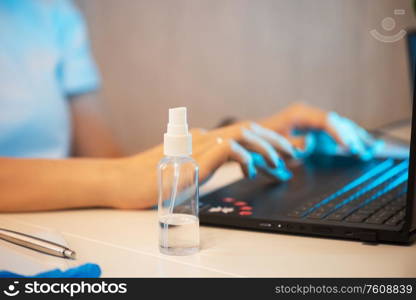 Woman in quarantine for coronavirus covid-19 working from home. Protective mask and Sanitizer spray on the working place. working from home