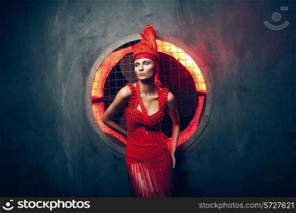 woman in red and concrete wall behind