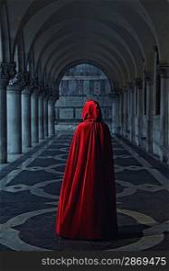 Woman in red cloak walking away