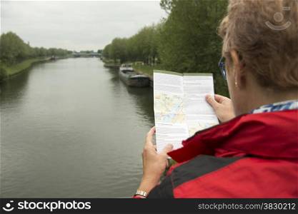 woman in red coat reading the information about a route