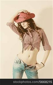Woman in red cowboy hat, jeans and shirt on white background