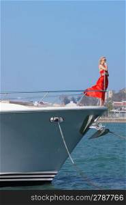Woman in red dress on bow of boat