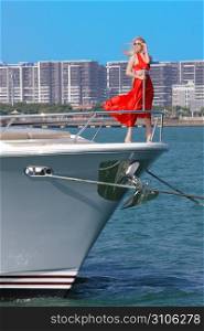 woman in red dress on bow of boat