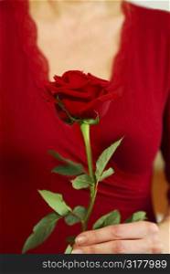 Woman in red holding a red rose