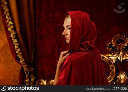 Woman in red hood in luxury interior