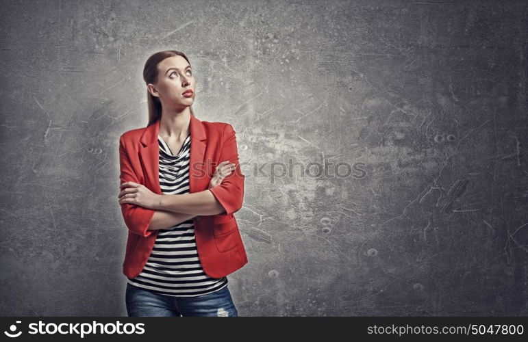 Woman in red jacket. Portrait of young woman in red jacket with arms crossed on chest looking away