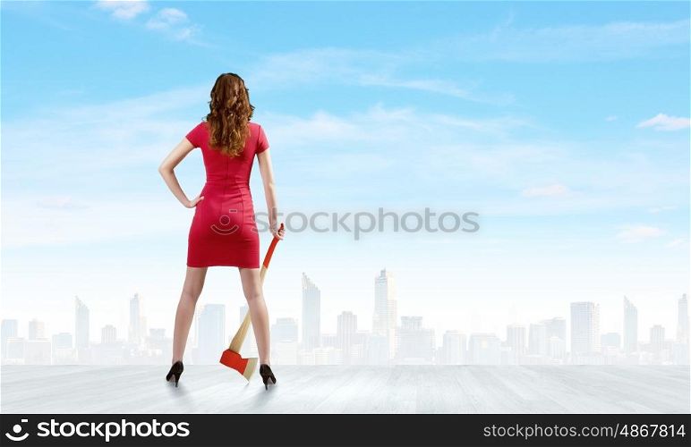 Woman in red. Rear view of woman in red dress with axe in hand