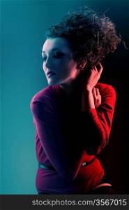 Woman in red with high curly hair in blue light