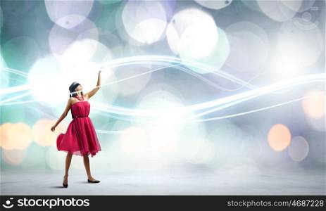 Woman in red. Young attractive woman in red dress touching light spot