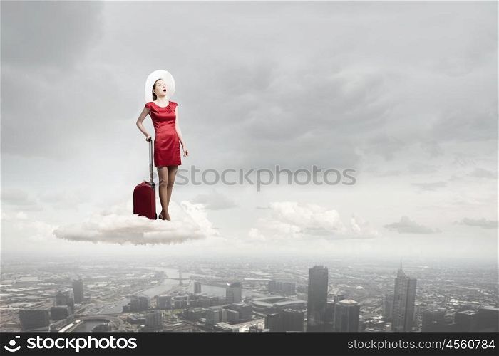 Woman in red. Young emotional woman in red dress with red luggage