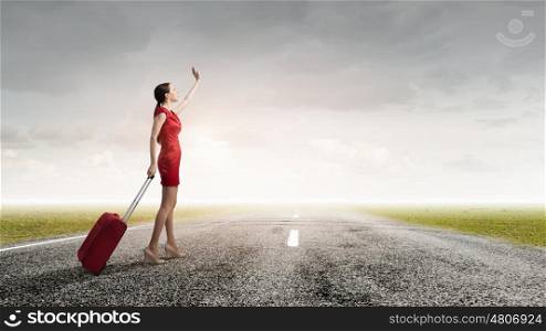 Woman in red. Young woman in red dress on road with red luggage