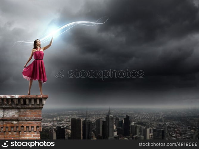 Woman in red. Young woman in red dress standing on top of building
