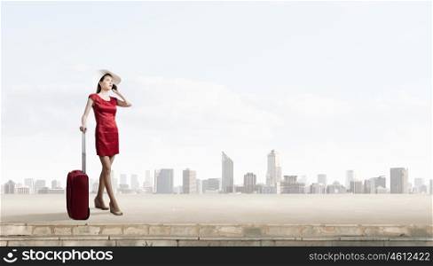 Woman in red. Young woman in red dress with red luggage talking on mobile phone