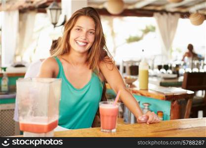 Woman In Restaurant Making Fruit Smoothies