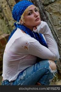 Woman in ripped clothing with blue headscarf