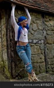 Woman in ripped clothing with blue headscarf