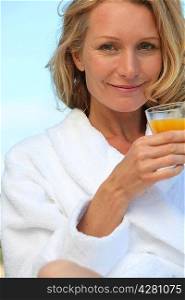 Woman in robe with glass of juice