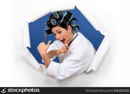 Woman in rollers with hairdressing scissors