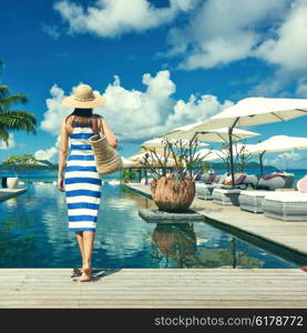 Woman in sailor striped dress near poolside jetty at Seychelles