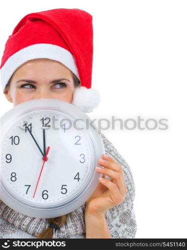 Woman in Santa hat holding clock in front of face and looking on copy space