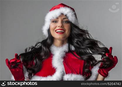 Woman in Santa style costume. Beautiful brunette woman with gorgeous curly hair in christmas Santa claus style costume