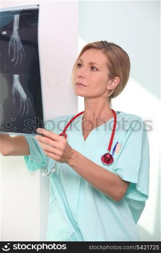 Woman in scrubs with stethoscope and clipboard