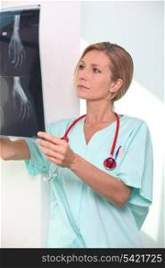 Woman in scrubs with stethoscope and clipboard