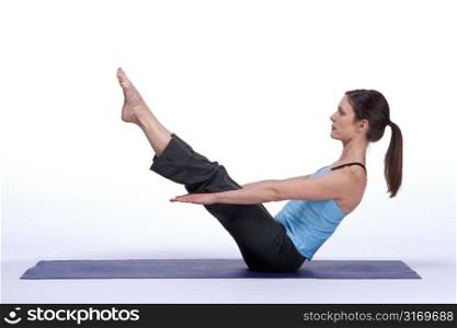 Woman in Seated Balancing Yoga Pose on Mat