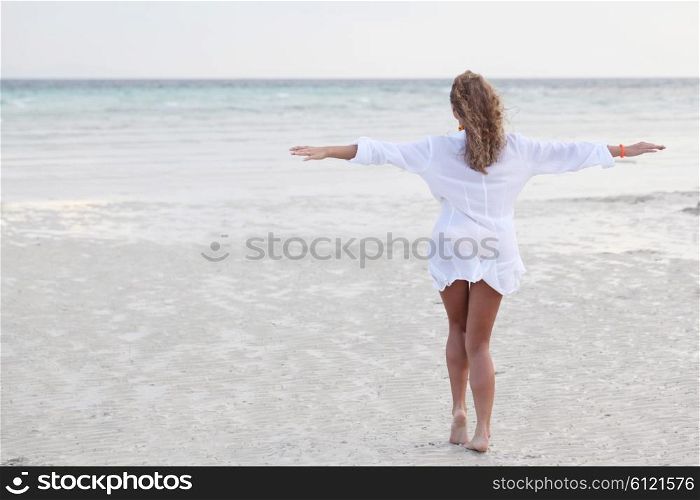 Woman in shirt on beach. Relaxed woman enjoying freedom and life on a beautiful sandy beach