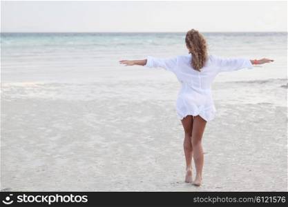 Woman in shirt on beach. Relaxed woman enjoying freedom and life on a beautiful sandy beach